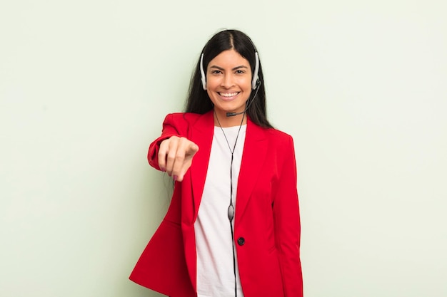 Young pretty hispanic woman pointing at camera choosing you telemarteker concpet