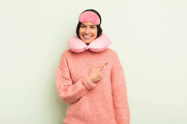 Young pretty hispanic woman smiling cheerfully, feeling happy and pointing to the side. plane passenger concept