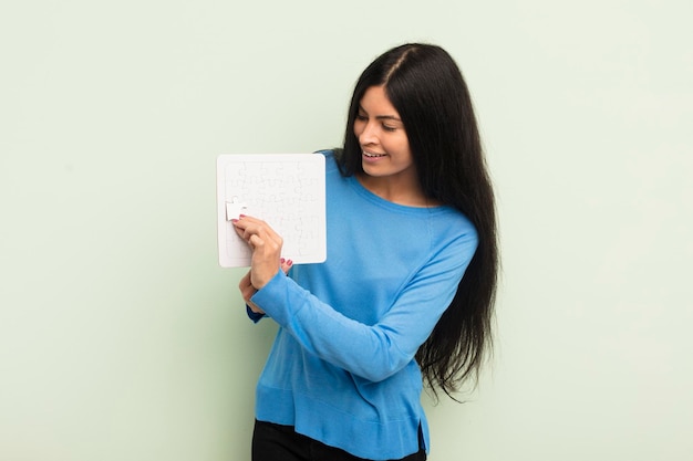 Young pretty hispanic woman with a puzzle