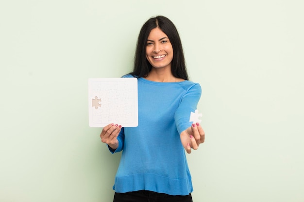 Young pretty hispanic woman with a puzzle