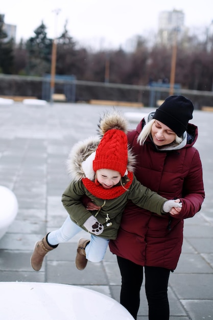 Young pretty mother hugging her cute little preschool daughter smiling