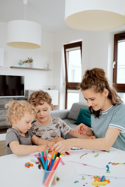 A young pretty mother is sitting at the kitchen table with her preschoolaged daughter