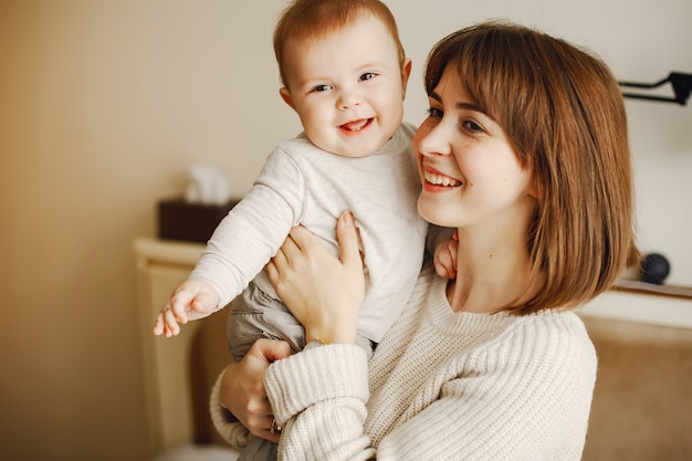 young and pretty mother playing with her son at home