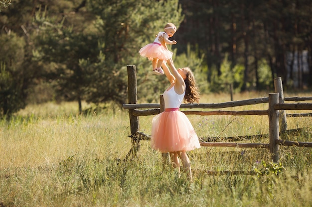 Young pretty mother with her little baby outdoors. Beautiful woman with her daughter on the nature. infant child with her parent