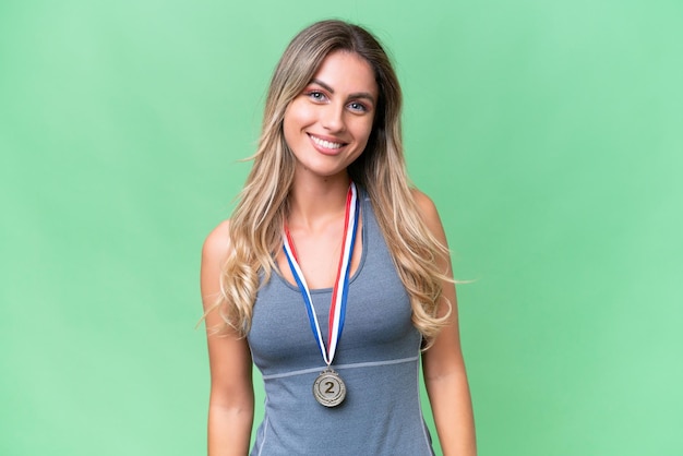 Young pretty sport Uruguayan woman with medals over isolated background laughing