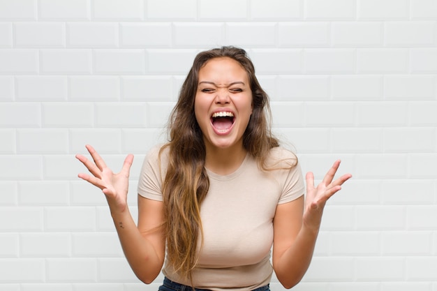 young pretty woman against white wall