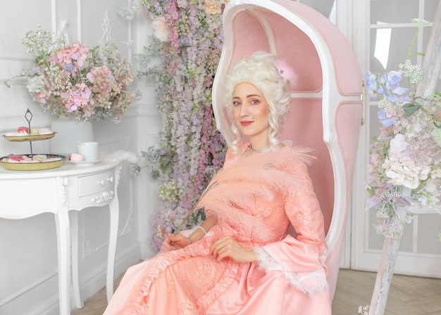 Young pretty woman closeup in pink royal dress Marie Antoinette cosplay