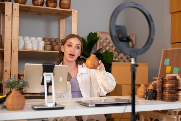 A young pretty woman entrepreneur live streaming to sale craft products to customers in her shop T