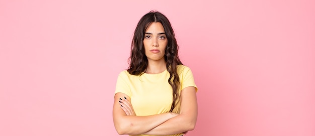 Young pretty woman feeling displeased and disappointed, looking serious, annoyed and angry with crossed arms