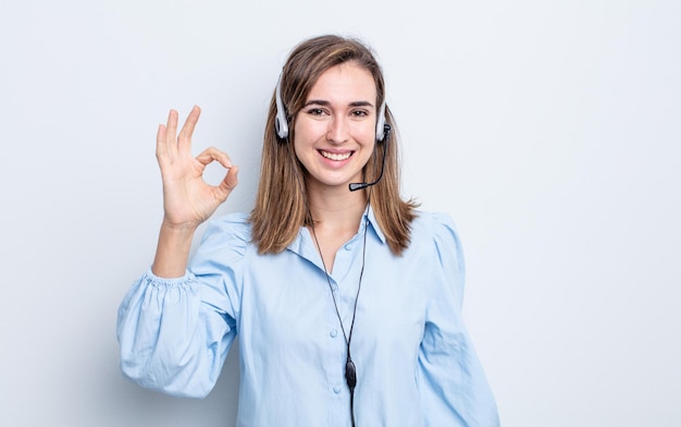 Young pretty woman feeling happy, showing approval with okay gesture. telemarketer concept