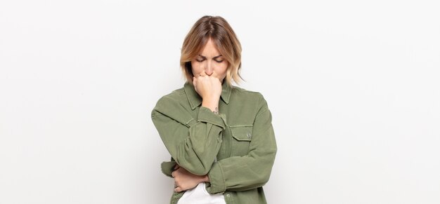 Young pretty woman feeling serious, thoughtful and concerned, staring sideways with hand pressed against chin