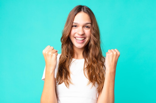 Young pretty woman feeling shocked,laughing and celebrating success