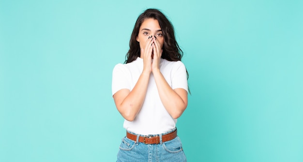 Young pretty woman feeling worried, upset and scared, covering mouth with hands, looking anxious and having messed up