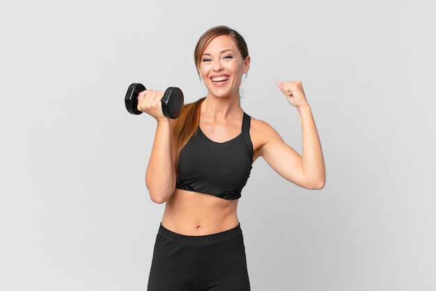 Young pretty woman fitness concept and lifting a dumbbell