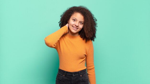 Young pretty woman gesturing on colored wall