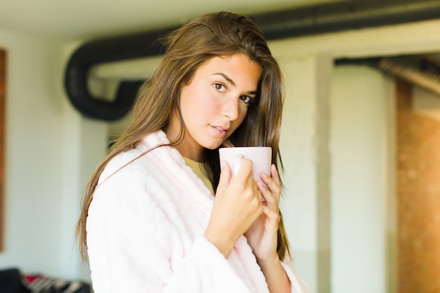 Young pretty woman having breakfast at home