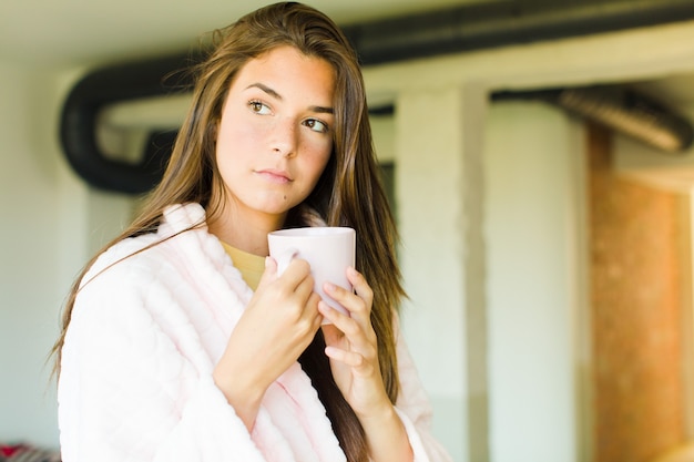 Young pretty woman having breakfast at home