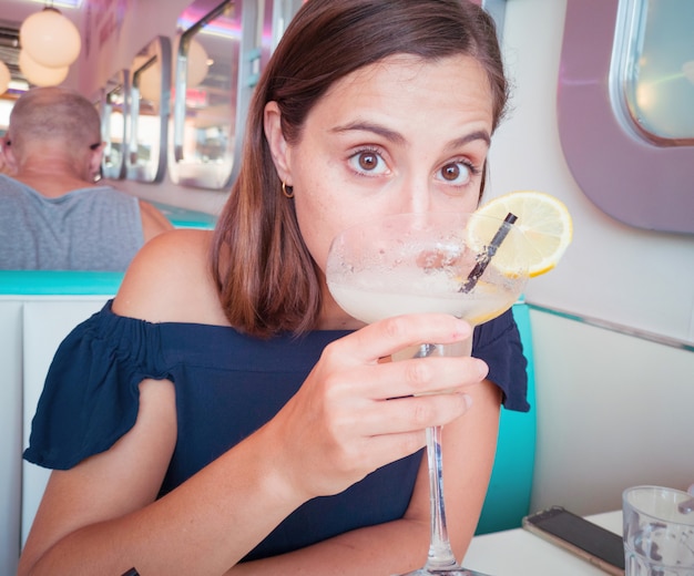 Photo young pretty woman having a fresh mojito cocktail in a restaurant