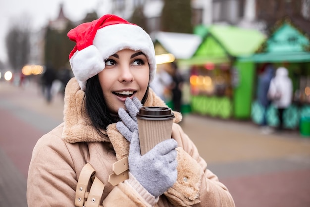 Young pretty woman hold hot beverage drink coffee