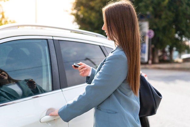 Young pretty woman holding car keys at outdoors