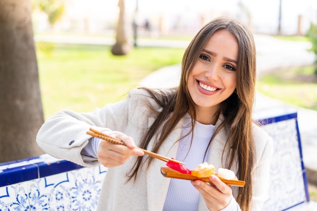 Young pretty woman holding sashimi at outdoors