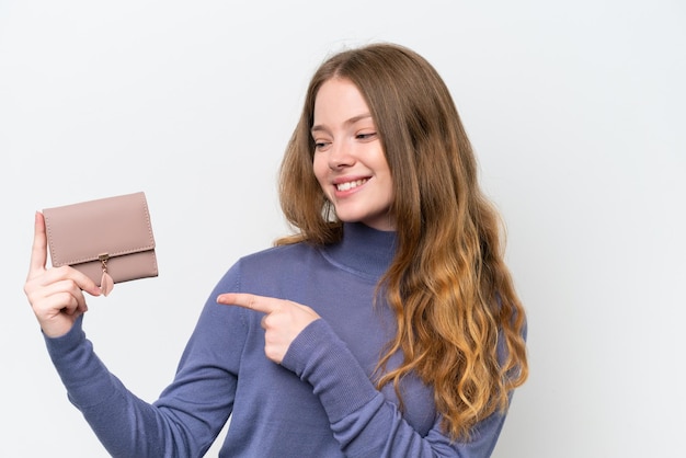 Young pretty woman holding wallet isolated on white background and pointing it