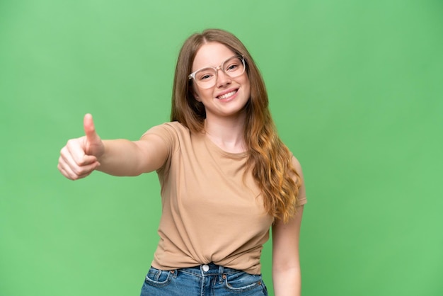 Photo young pretty woman over isolated background with thumbs up because something good has happened