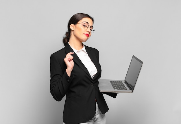 Young pretty woman looking arrogant, successful, positive and proud, pointing to self. laptop concept