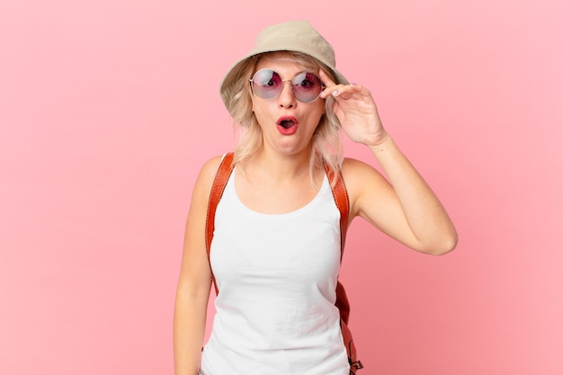 Young pretty woman looking happy, astonished and surprised. summer tourist concept