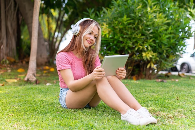 Young pretty woman at outdoors listening music with the mobile