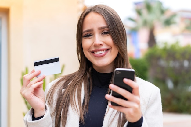 Young pretty woman at outdoors making a selfie with mobile phone