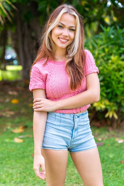 Young pretty woman at outdoors with happy expression