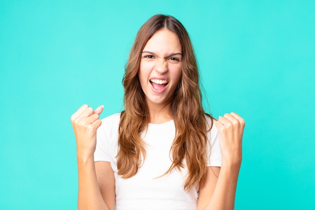 Young pretty woman shouting aggressively with an angry expression