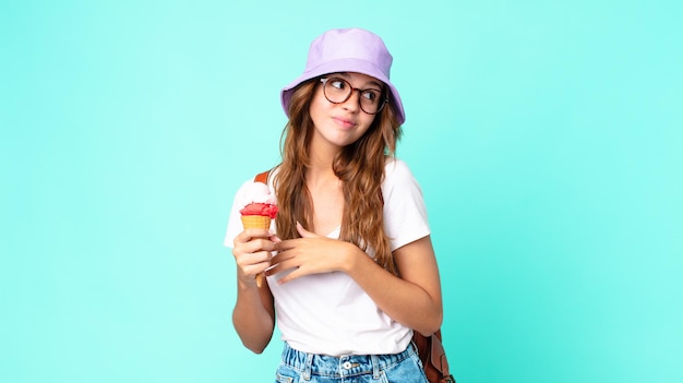 Young pretty woman shrugging, feeling confused and uncertain holding an ice cream. summer concept