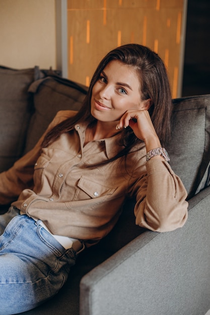 Young pretty woman sitting on coach in a cafe