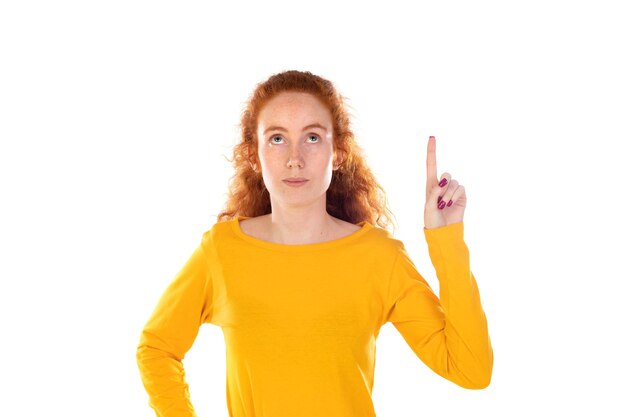 Young pretty woman smiling confidently pointing to something positive relaxed satisfied attitude against white background