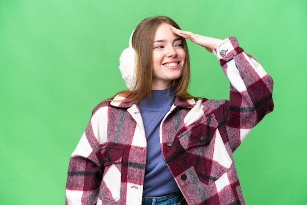 Young pretty woman wearing winter muffs over isolated chroma key background has realized something and intending the solution