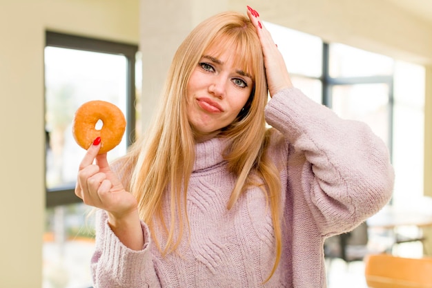 Photo young pretty woman with a donut unhealthy diet concept at home interior