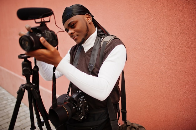 Young professional african american videographer holding professional camera with pro equipment Afro cameraman wearing black duraq making a videos