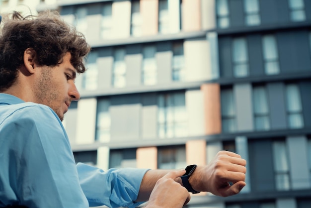 Young progressive businessman using touchscreen smartwatch to check time