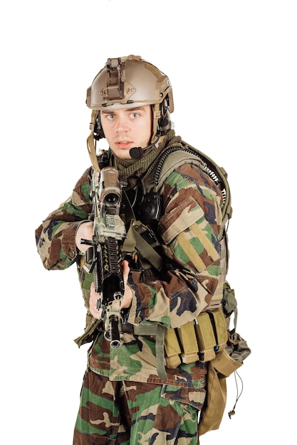 Young ranger standing with a machine gun at white background