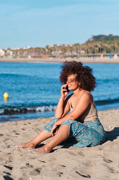 A young real woman using smartphone at Barcelona beach