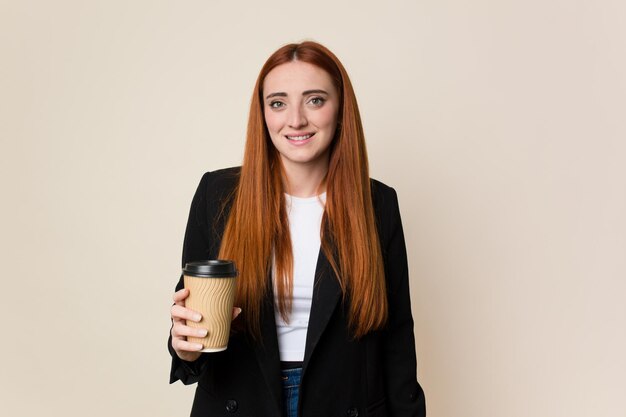 Young red hair woman holding a takeaway coffee isolated