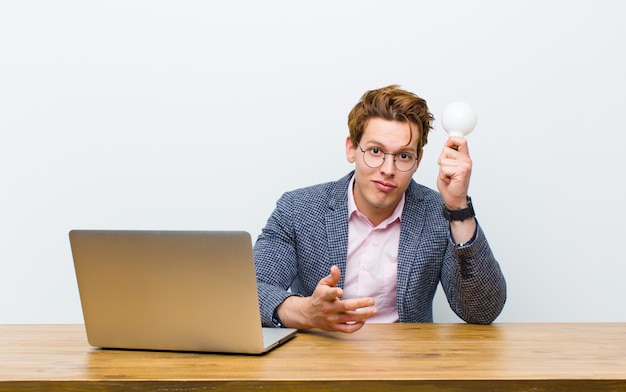 Young red head businessman working in his desk having an idea