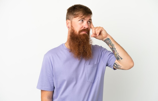 Young reddish caucasian man isolated on white background making the gesture of madness putting finger on the head