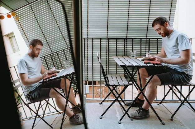 Young redhead man focus on reading a book at home