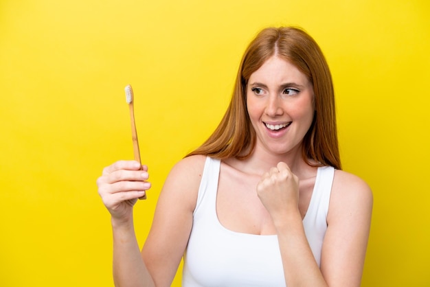 Young redhead woman brushing teeth celebrating a victory