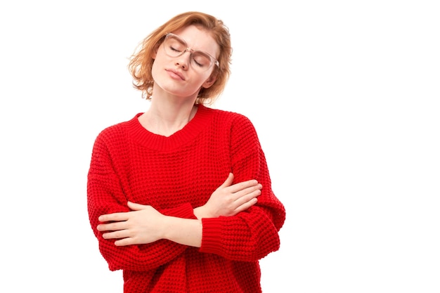 Young redhead woman hugging herself and smiling isolated over white studio background self love and self care concept