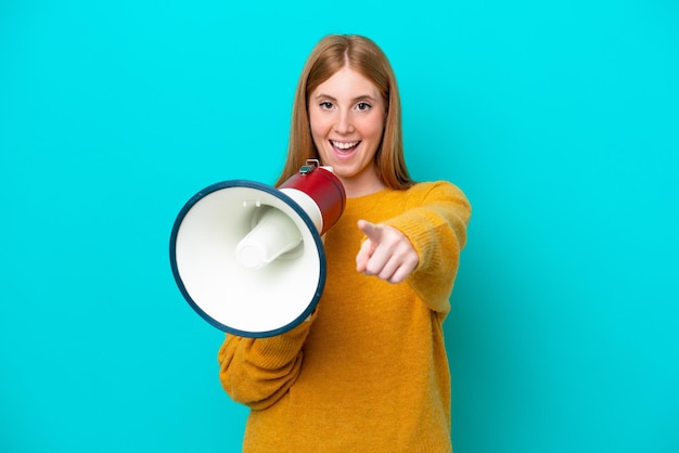 Young redhead woman isolated on blue background