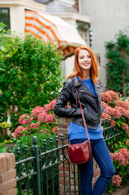 Young redhead woman standing at street in the city of Amsterdam in springtime.